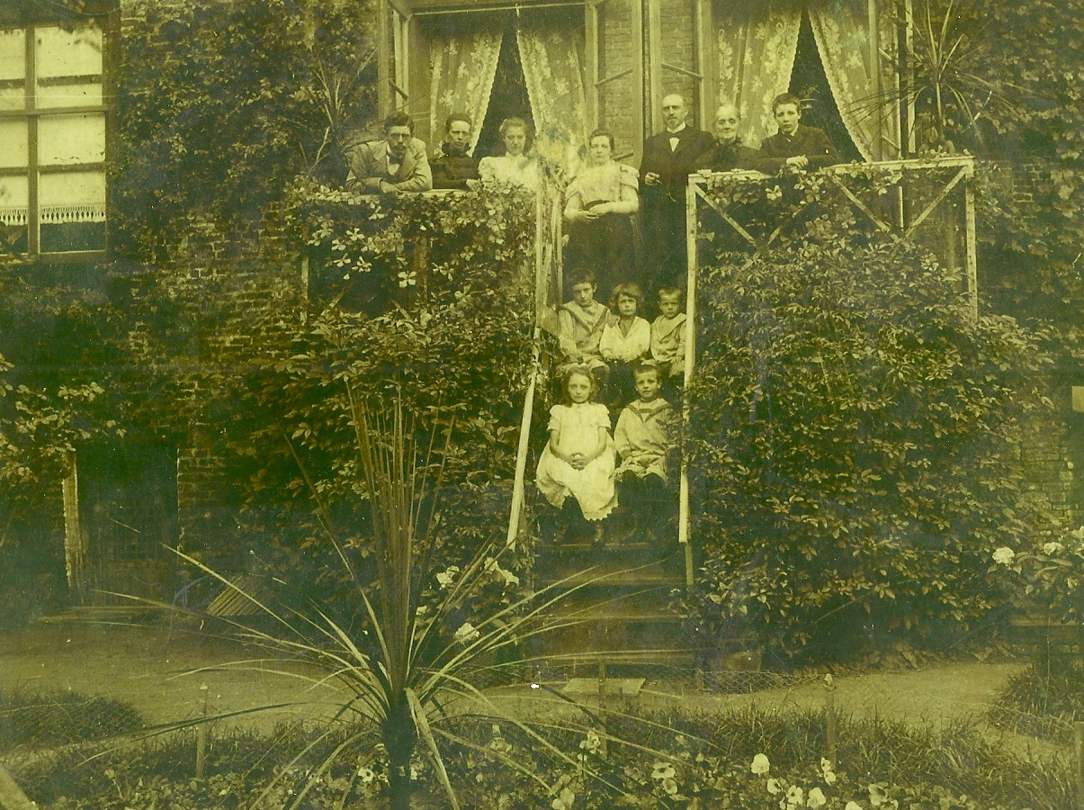 Hinterhof Pfarrhaus im Axel: 7. August 1899; Marie Katz Geesink (Schwester von meiner Urgroßmutter Mathilde) besucht die Familie in Axel.
Auf der Balustrade: 
Johan Rudolf Katz (1880-1938); Marie Katz-Geesink; Frida Katz (1885-1963); Mathilde Hugenholtz-Geesink (1865-1942); JBT Hugenholtz (1859-1922); Ur-Ur-Großmutter Geesink-Reuver (1824-1917); Charles Fredrik Katz (1883-1942). 
Auf der Treppe in vorne: Han (JBTh 1888-1973), Henk (HSJ (1895-1956), Co (CAJ 1893-1917); 
Unten: Gemma (1891-1960), Gerhard (1889-1969).