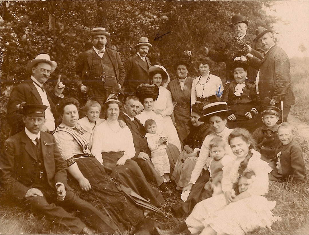 With family/friends in Danmark, Gretchen with large hat and black belt (son Hans in front of her); Carl Lehmkuhl in the back (arrow)